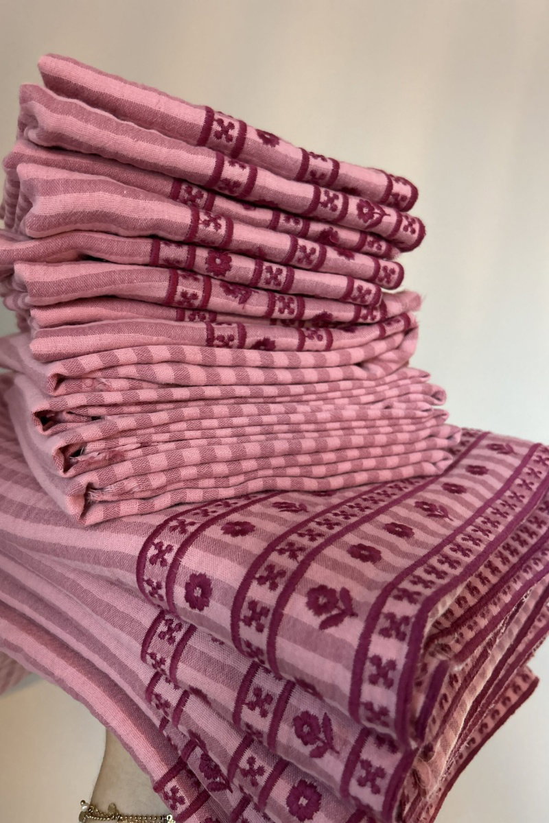 Stapeltje hydrofiele doeken met roze streepjes geborduurde bloemetjes